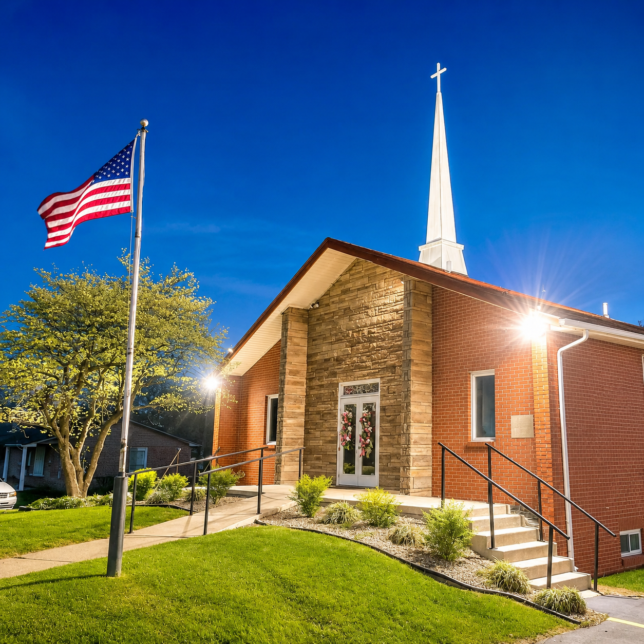 Eastland First Church of God exterior at night with steeple and American flag